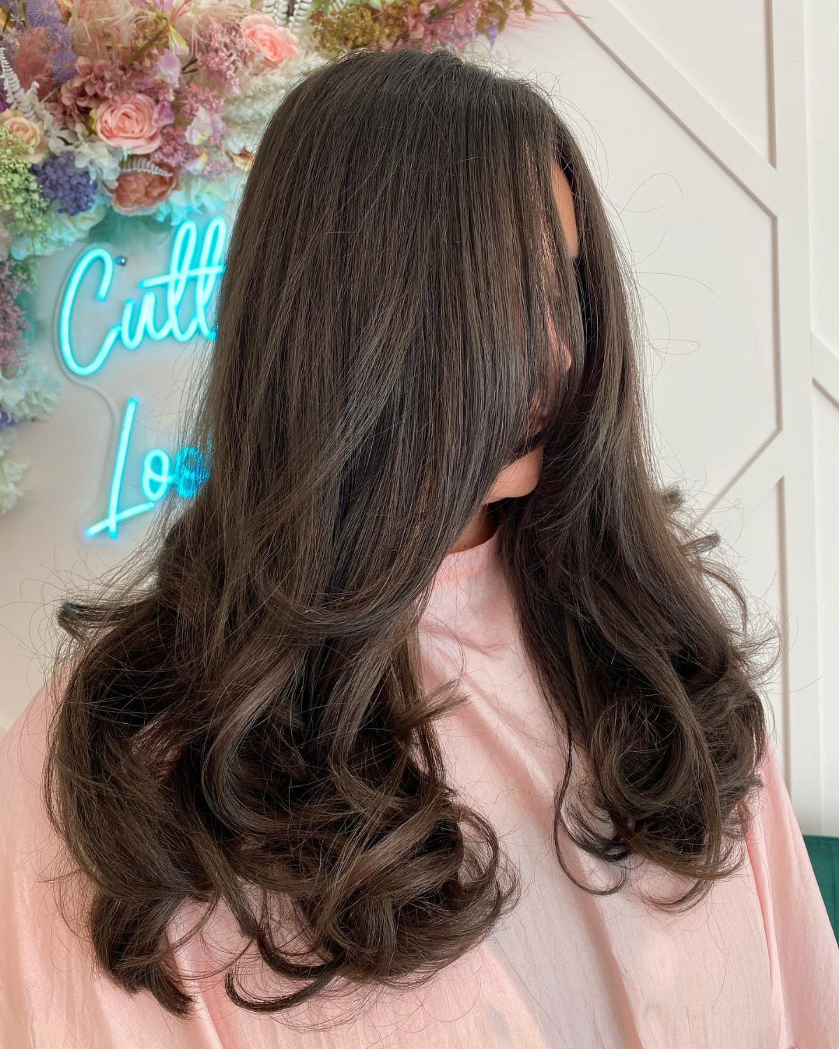 Long dark brown hair styled with voluminous layers and bouncy curls on a person.