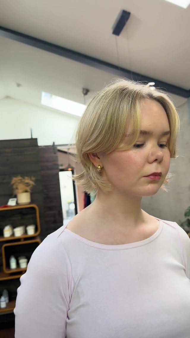 A blonde woman with a short bob hairstyle featuring flipped out ends.