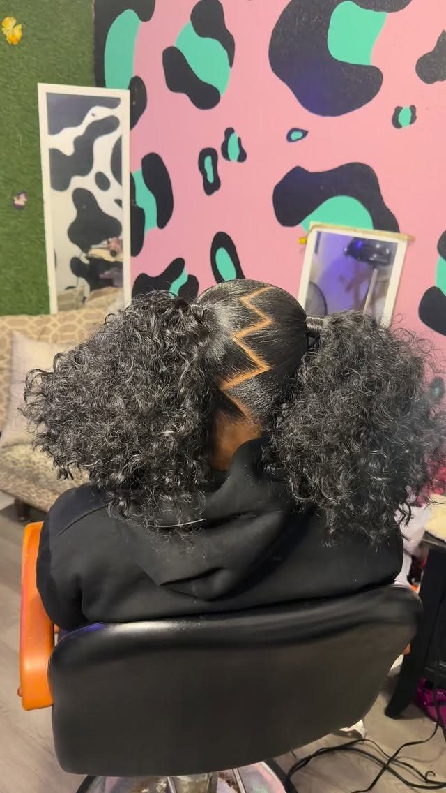 Curly hair styled in two high pigtails with a sharp zig-zag part.
