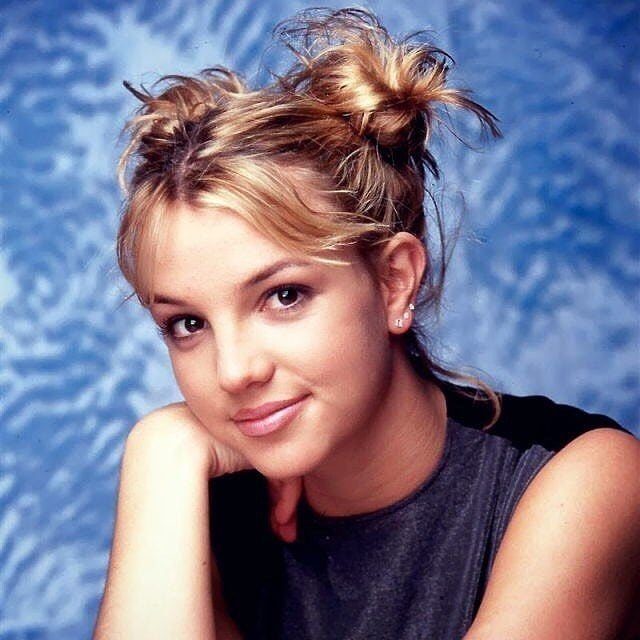 90s Hairstyles Short and 6 Ideas We Still Want to Copy 6 Blonde woman with hair styled into two small buns and loose face-framing tendrils.