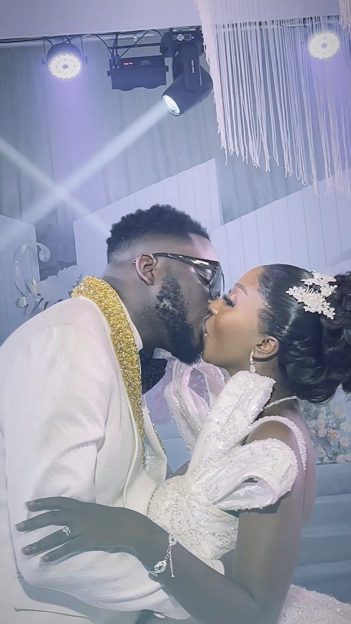 A bride and groom sharing a romantic kiss during their wedding celebration.