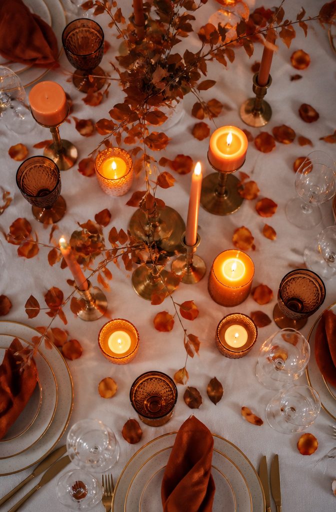 20 Burnt Orange Wedding Decor Ideas for 2026 8 Burnt orange taper and pillar candles arranged on tables.