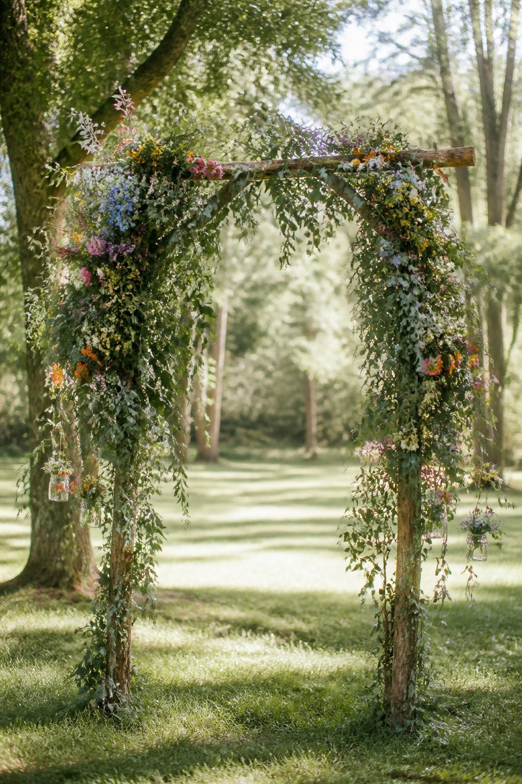 A floral arch featuring wildflowers and eucalyptus on a wooden frame.