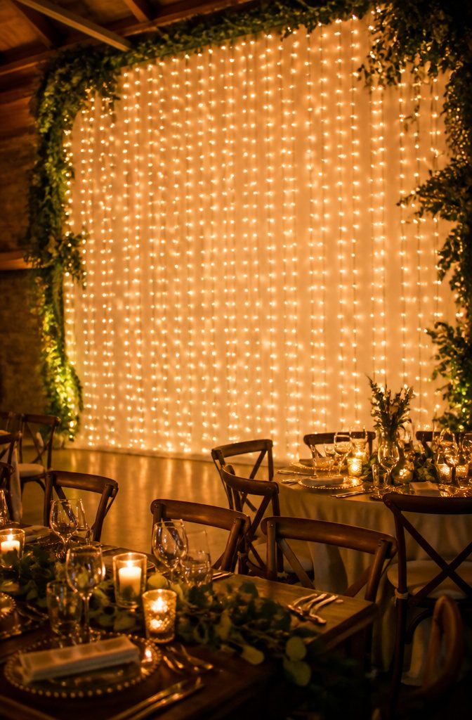 A wall densely packed with pea lights at a wedding.