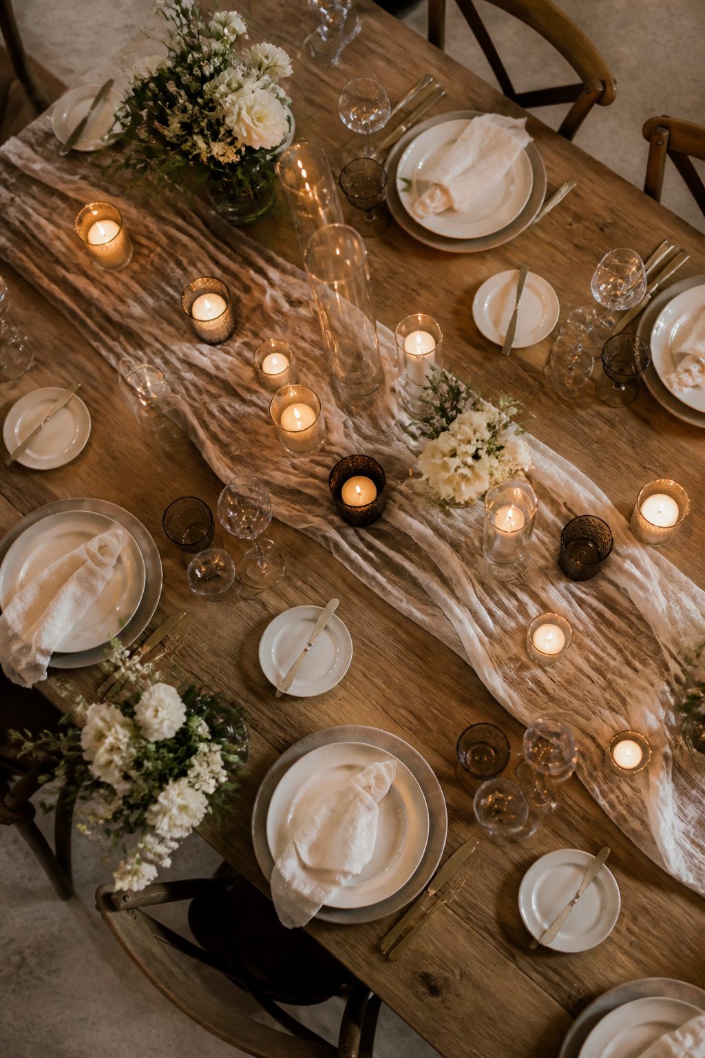 A variety of candles and glassware arranged together on a table.