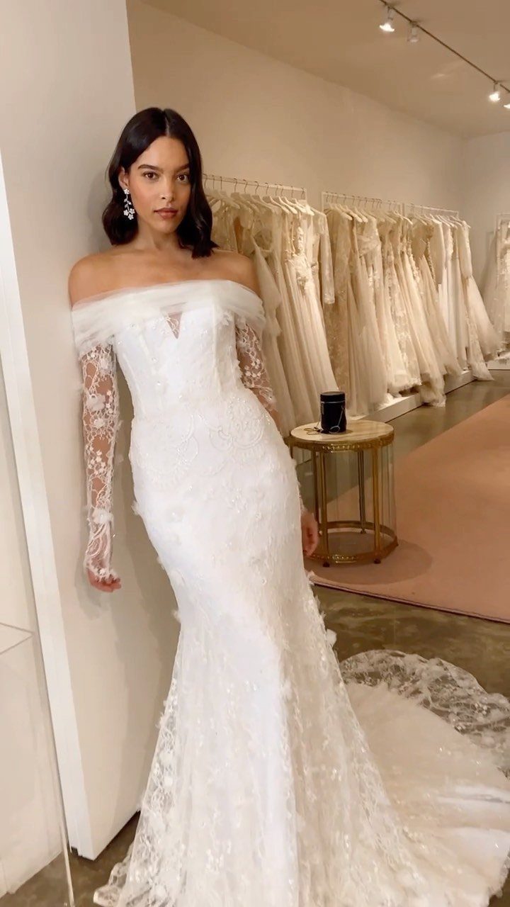 Tight Lace Wedding Dress: 8 Fitted Styles to Shape the Day 3 Woman wearing a white off-the-shoulder mermaid wedding dress with long lace sleeves.