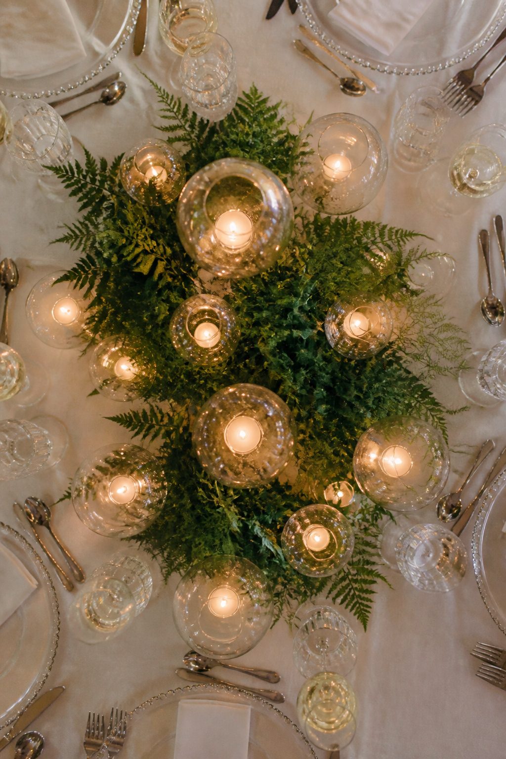 Glass orbs of varying heights clustered on a table.