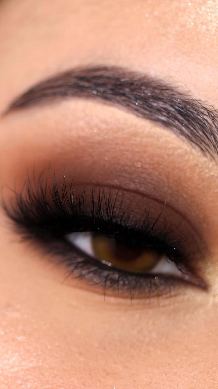 Close-up of an eye with dark brown eyeshadow applied heavily to the outer corner.