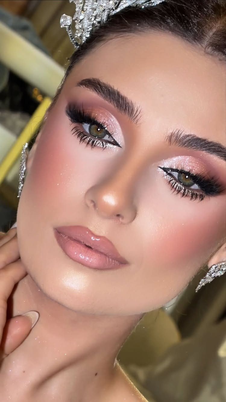Woman with glamorous makeup featuring silver glitter eyeshadow and pink tones.