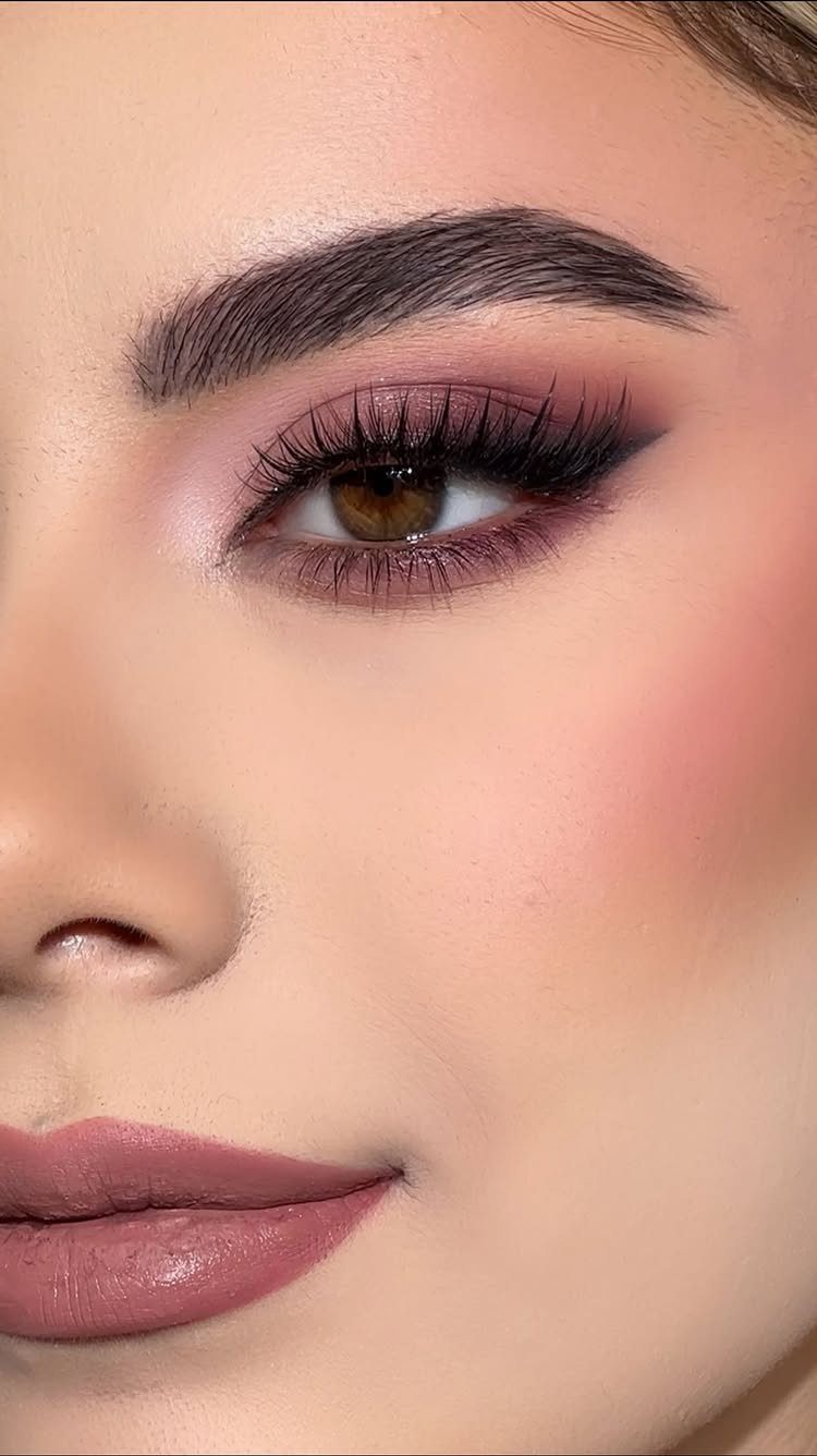 Close-up of a person wearing soft mauve eyeshadow and matching pink lipstick.