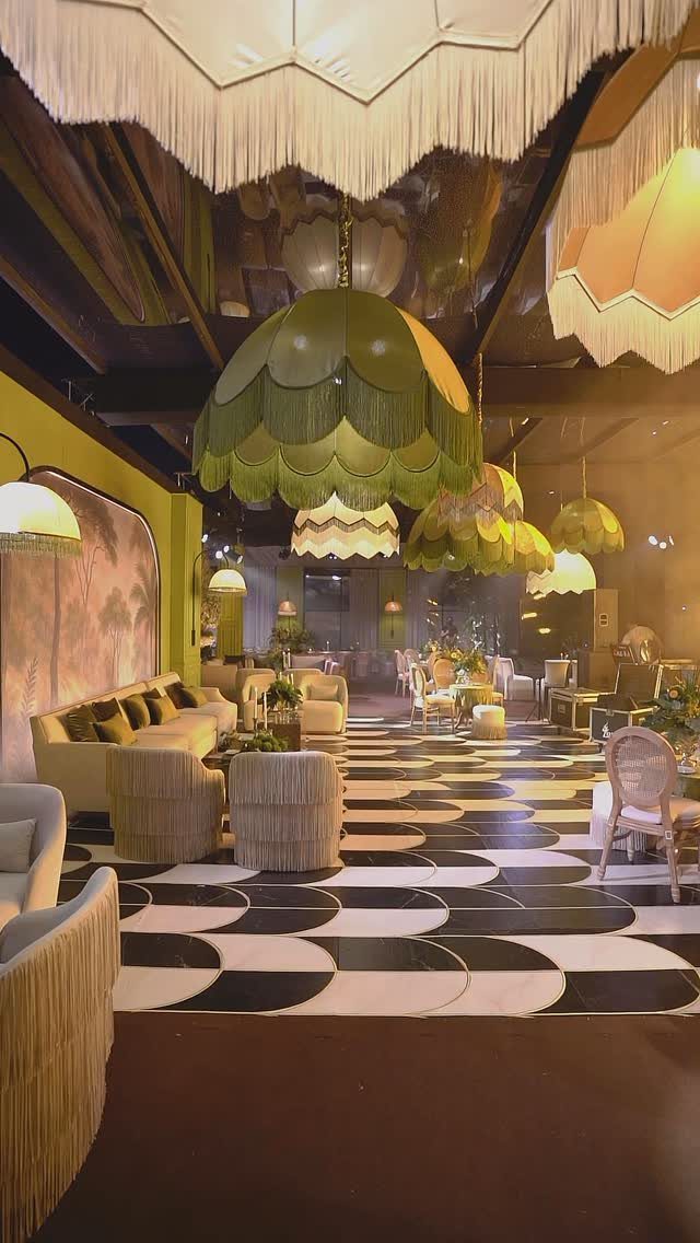 Cream sofas and armchairs arranged in a lounge area with large decorative pendant lights.