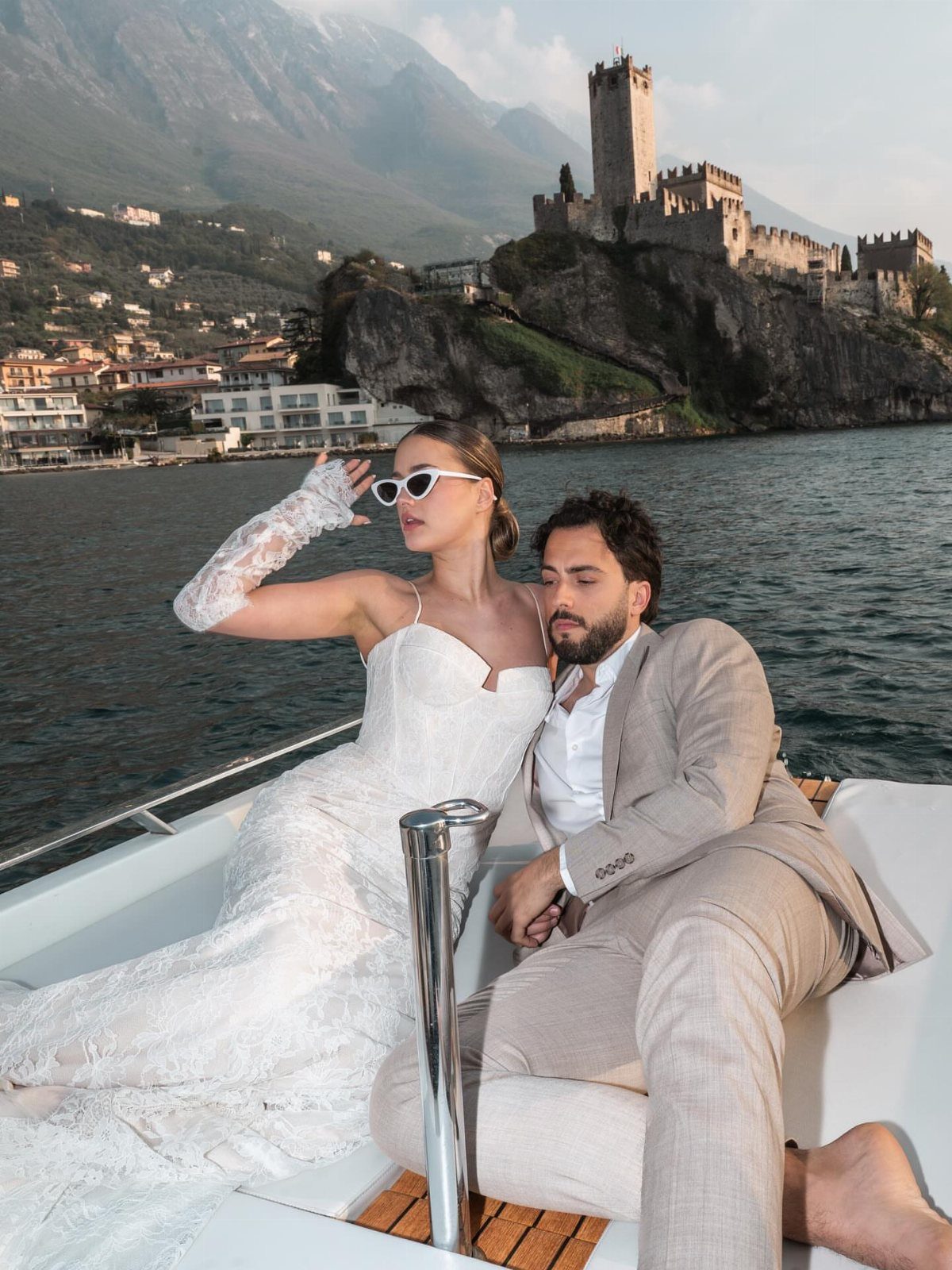 Wedding Outfit for Europe: 6 Ideas for 2026 Ceremonies Abroad 6 A bride in lace and a groom in a linen suit relaxing on a boat.