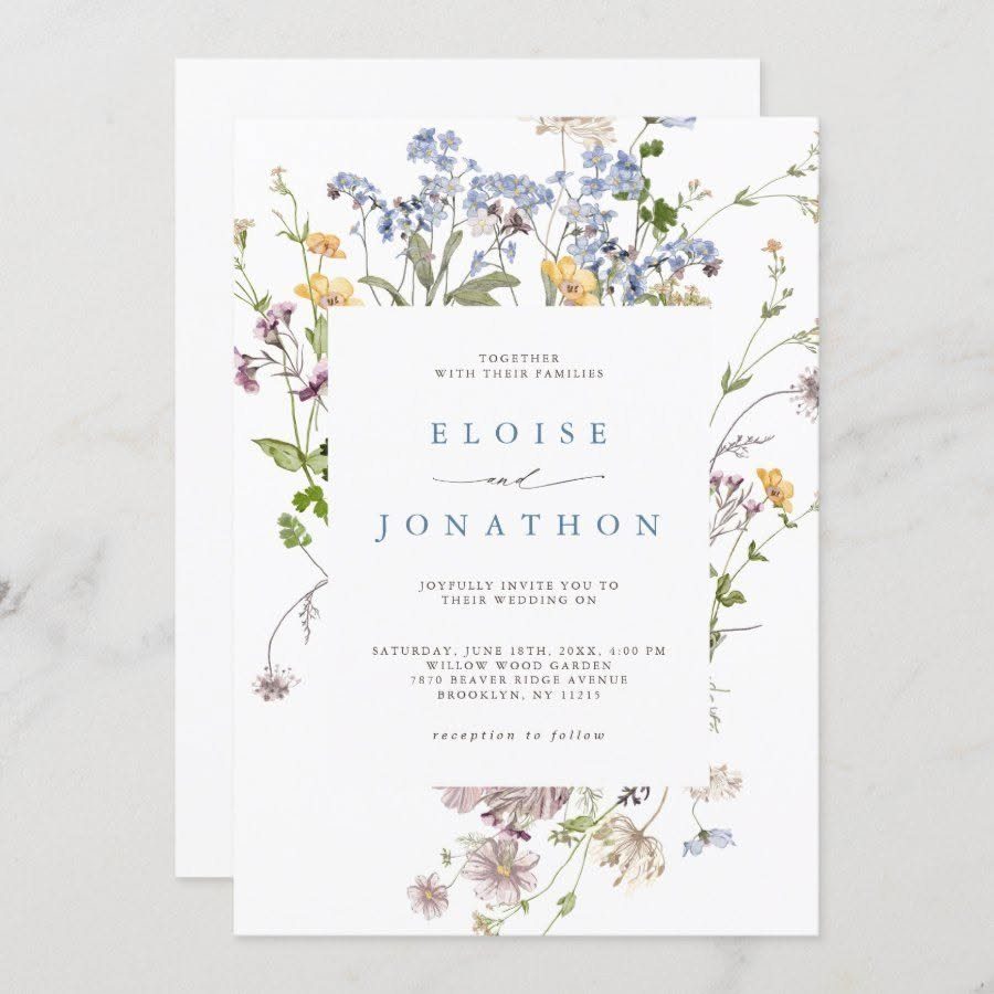 A wedding invitation with colorful watercolor wildflowers and elegant blue typography on white paper.