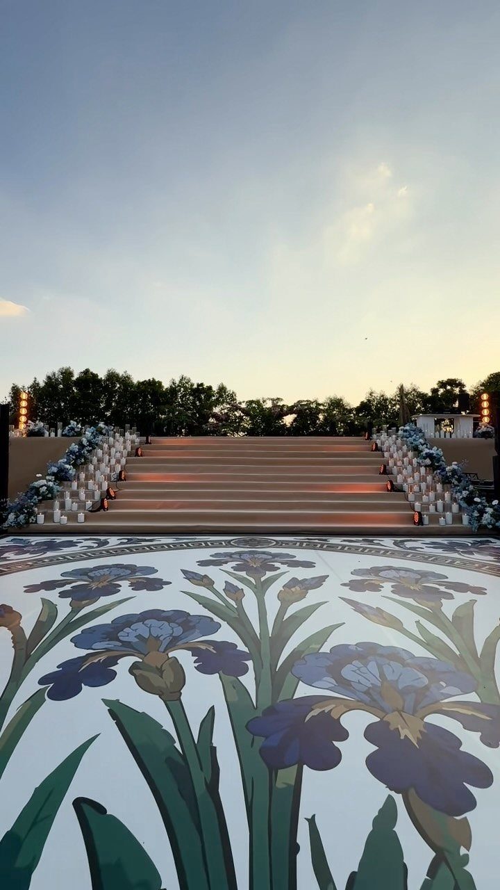 Large blue and purple iris floral patterns painted on a white wedding dance floor.